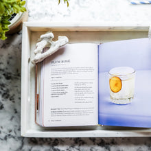 Load image into Gallery viewer, Open Rosé Cocktails recipe book showing "Plum Rosé" cocktail recipe and drink photo on a white tray. 