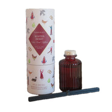 Load image into Gallery viewer, A ribbed ruby colored glass diffuser, a set of black reeds, and its cylindrical packaging container.  Container is white with decorations and a burgundy colored triangle label. Label has the text &quot;PADDYWAX&quot;, and &quot;WINTER BERRY&quot;. 
Decorations on the container include: two golden rings, a goose, a hen, a dove, a milkmaid, a person playing the trumpet , and a pear. All against a white background. 
