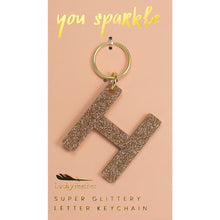 Load image into Gallery viewer, Gold glittery letter &quot;H&quot; keychain on a pink card with &quot;you sparkle&quot; in gold text, displayed against a white background.