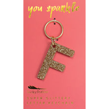 Load image into Gallery viewer, Gold glittery letter &quot;F&quot; keychain on a pink card with &quot;you sparkle&quot; in gold text, displayed on a white background.