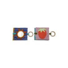 Load image into Gallery viewer, Two fabric toys with circular and square designs on a white background