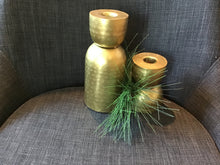 Load image into Gallery viewer, Tall and short size stamped brass candlestick holders with textured finish against a gray background with greenery.