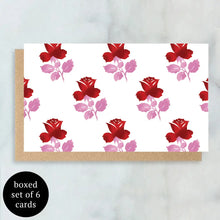 Load image into Gallery viewer, Mini greeting card with a white background and a repeating red rose and pink leaves and stems pattern, shown on top of a brown kraft paper envelope.