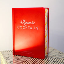 Load image into Gallery viewer, Red book titled "Romantic Cocktails" on a striped surface with a light gray background.