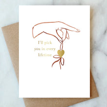 Load image into Gallery viewer, Gold foil "I'll pick you in every lifetime" greeting card shown on a kraft paper envelope. 