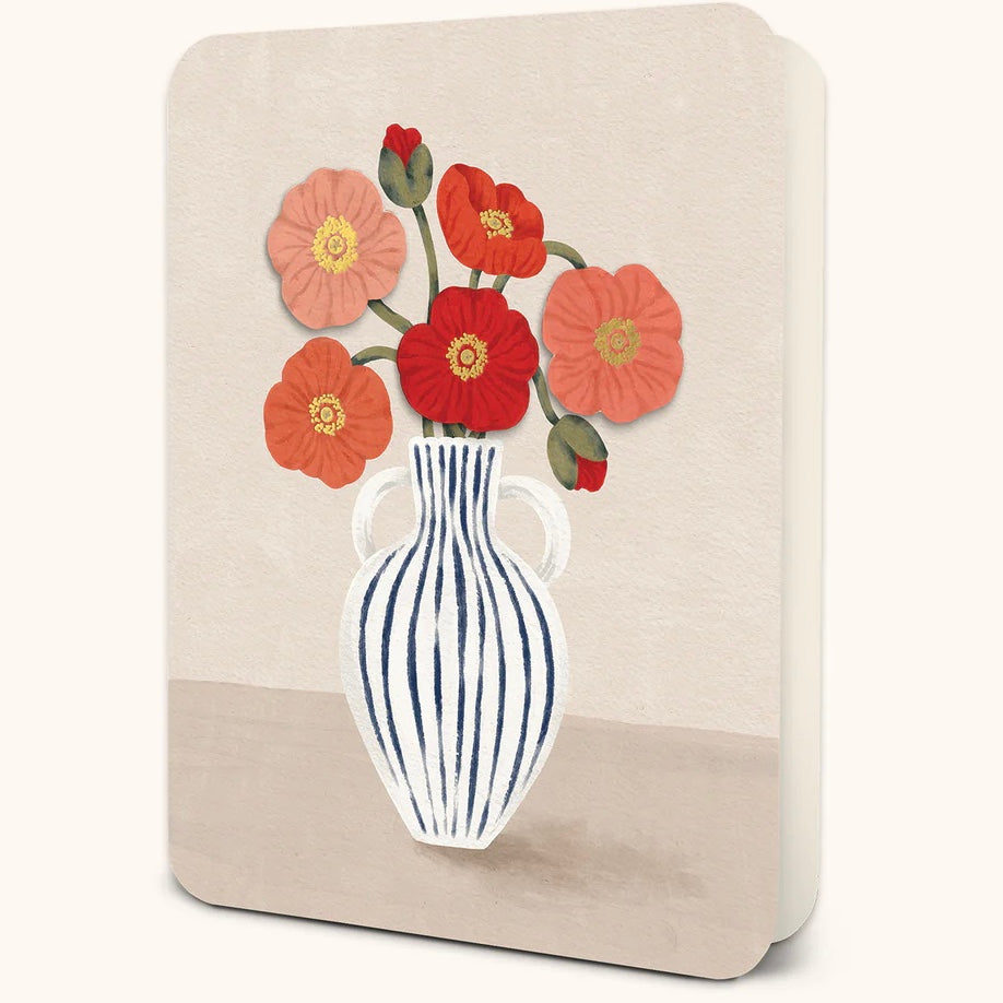 Greeting card featuring an illustration of a white vase with navy vertical stripes filled with red, coral, and pink poppy flowers. Displayed against a white background.  
