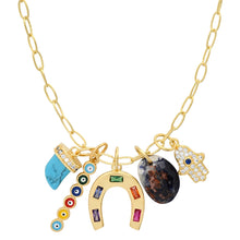 Load image into Gallery viewer, Gold-tone charm necklace displayed on a white background featuring a turquoise-colored horn charm, a faceted brown stone charm, a gold horseshoe charm with multi-colored inlays, a small vertical multicolored evil eye charm, and a pave hamsa hand charm. 