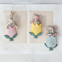 Load image into Gallery viewer, Three plush animals with flower-shaped bags in different colors placed on a book on a white surface. Plushies are a bunny in a pink tulip, a pig in a yellow tulip, and an elephant in a blue tulip.