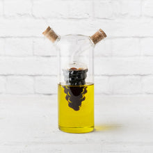 Load image into Gallery viewer, Clear glass oil and vinegar cruet with cork stoppers and an interior grape-bunch motif on a white background.