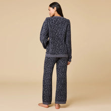 Load image into Gallery viewer, Back view of a person wearing a gray knit lounge set with a black leopard print pattern. The relaxed-fit sweater and wide-leg pants have gray ribbed cuffs and hems, shown against a soft beige background. 