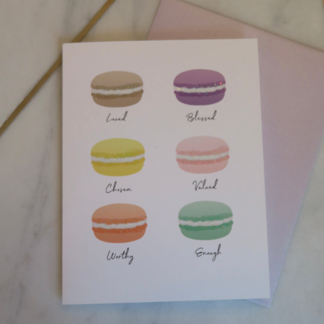 Card with illustrations of macarons and text on a marble surface