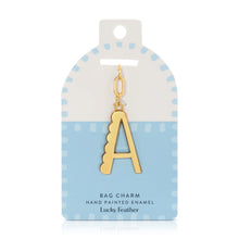 Load image into Gallery viewer, 14K gold-plated hand-painted enamel initial bag charm featuring the letter A with a scalloped edge design and a brushed gold finish, attached to a key ring and clasp. Displayed on a white and light blue Lucky Feather card featuring light blue dotted brush-stroke borders and labeled &quot;Bag Charm Hand Painted Enamel.&quot; Displayed against a white background. 