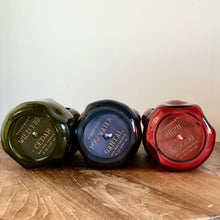 Load image into Gallery viewer, Three glass containers with labels on a wooden surface, against a white background. From left to right : Green tinted glass container with a green label and the text &quot;PADDYWAX&quot; and &quot;WHITE FIG CEDAR&quot;. Blue tinted glass container with a blue label and the text &quot;PADDYWAX&quot; and &quot;ROSEWATER SANTAL&quot;.   Red tinted glass container with red label and the text &quot;PADDYWAX&quot;, and &quot;YUZU WOODS&quot; . 