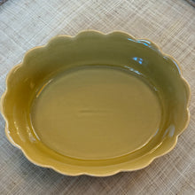 Load image into Gallery viewer, Oval olive-colored stoneware dish with scalloped edges displayed on a cream-colored textured surface.