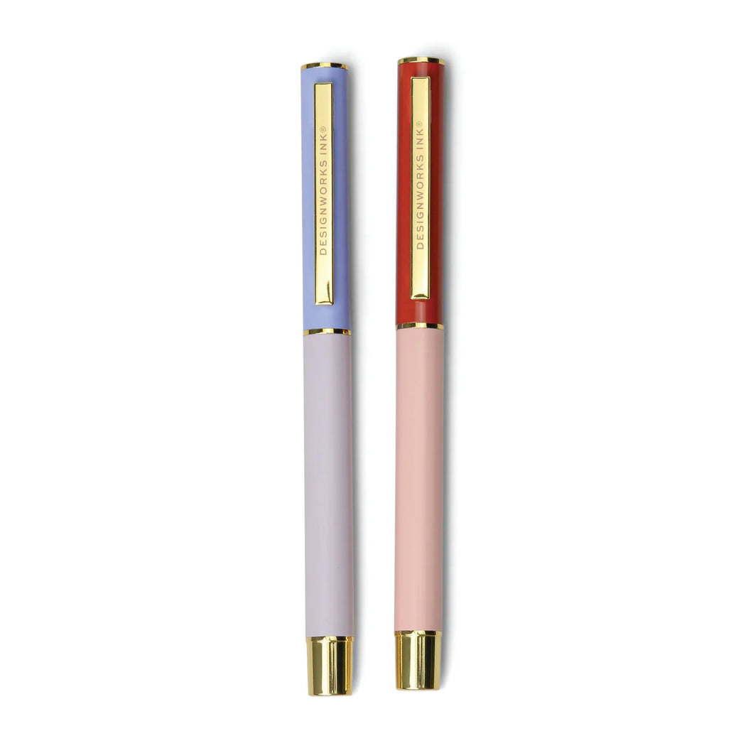 Two pens side by side on a white background. One is two-toned blue with gold details. The other is two-toned red with gold details. 