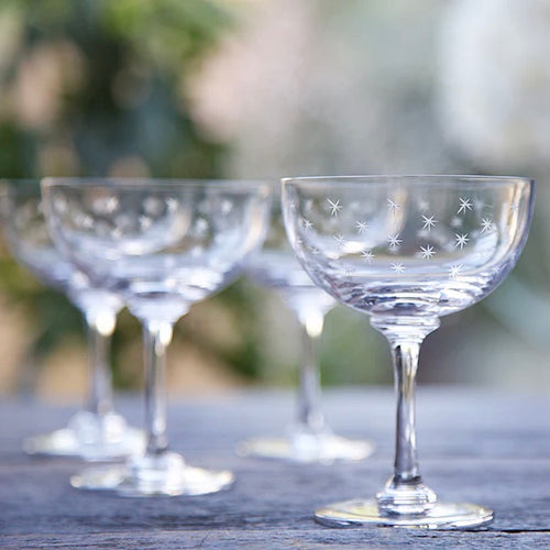 stemmed wine glasses on wooden table with blurred nature background. 
