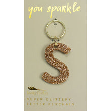 Load image into Gallery viewer, Gold glittery letter &quot;S&quot; keychain on a beige card with &quot;you sparkle&quot; in gold text, displayed against a white background. 
