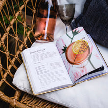 Load image into Gallery viewer, Open "BUBBLY" cocktail book displaying Hibiscus Fizz recipe with styled drink, rosé bottle, and goblet nearby, displayed on a woven surface.  