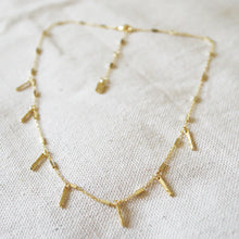 Load image into Gallery viewer, Double gold-plated choker necklace with handmade brass castings, displayed on a cream woven fabric background.  
