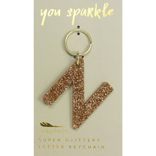 Load image into Gallery viewer, Gold glittery letter &quot;N&quot; keychain on a beige card with &quot;you sparkle&quot; in gold text, displayed against a white background.
