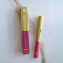 Load image into Gallery viewer, Yellow-and-pink flameless rechargeable lighter next to its matching box on a marble surface.