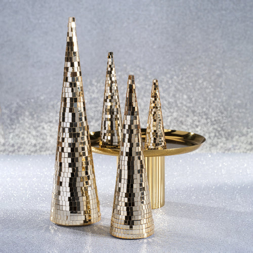 Collection of four gold prism cone decor trees with two large trees in the front and two smaller trees on a gold pedestal tray in the background, displayed on a shimmering silver surface and background.