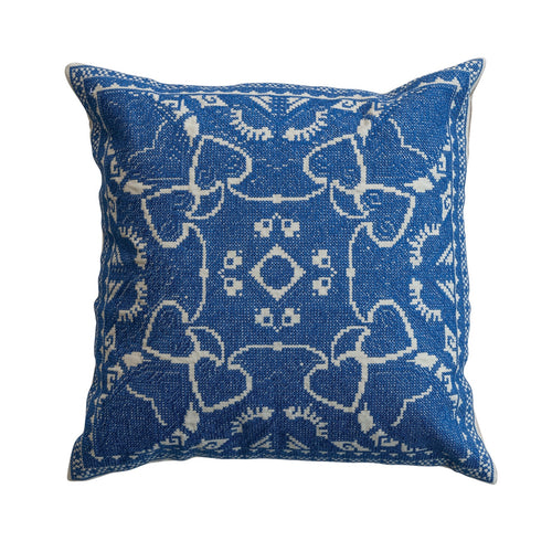 Blue pillow with white pattern on a white background.