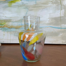 Load image into Gallery viewer, Tutti Frutti Decanter hand-blown glass with multicolor abstract design including yellow, orange, blue, red, and pink on wooden surface against abstract background. 