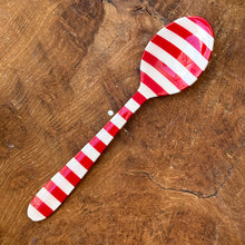 Load image into Gallery viewer, A red and white striped stainless steel spoon on a brown wooden surface. 