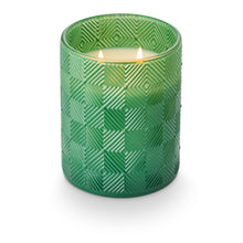 Load image into Gallery viewer, Jungle Green Magnolia Glass Candles, lit double-wick candle with white wax in jungle green glass vessel with raised diamond geometric pattern shown in angled top view against white background. 