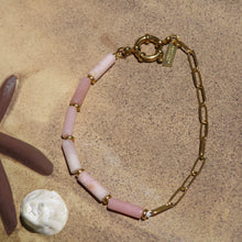 Load image into Gallery viewer, Bracelet with pink beads and gold chain on a beach background.