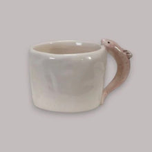 Load image into Gallery viewer, White ceramic mug with a fish-shaped handle on a light gray background