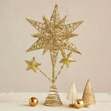 Load image into Gallery viewer, Gold Christmas tree topper with large star and two smaller stars , on a white surface and two gold miniature Christmas trees and two gold round ornaments against a white background.