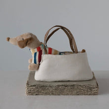 Load image into Gallery viewer, Small Dachshund stuffed animal  with a striped colorful sweater peeking out from a beige handbag on a textured surface.