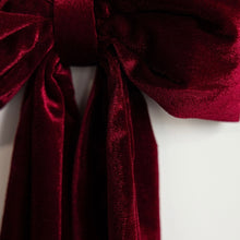 Load image into Gallery viewer, Velvet Bow Garland, close-up of deep red velvet bow with full loops and long hanging tails against a white background. 