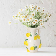 Load image into Gallery viewer, Large Jug with Lemons, white ceramic jug with a curved handle and raised yellow lemon and green leaf design, displayed with white daisy flowers, against a light textured background.  
