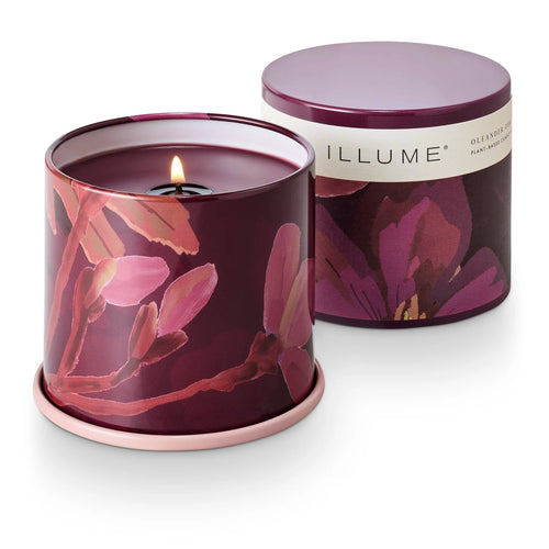 Floral-patterned candle in a purplish color container with 'ILLUME' branding on a white background