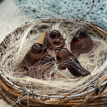 Load image into Gallery viewer, Mini translucent pink glass bird figurines arranged in woven twig nest with natural fiber lining. 