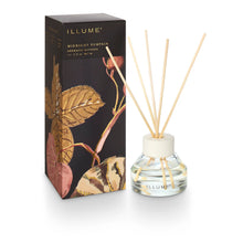Load image into Gallery viewer, Midnight Pumpkin Diffuser, front view of a clear glass bottle filled with clear liquid, featuring a cream-colored collar, natural-colored reeds, and the Illume logo in black along the bottom, beside a tall  rectangular dark brown box with gold-colored lettering and autumn botanical illustrations in gold, muted pink, and cream against a white background.