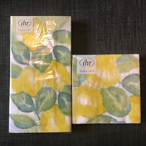 A package of paper guest towels and a package of guest washcloths with 'ihr' branding stickers on a dark textured background.
