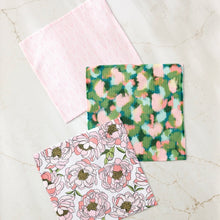 Load image into Gallery viewer, Geometry dishcloths with pink diamond pattern, abstract multicolor pattern, and pink peony floral pattern on separate towels, on a marble surface.