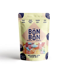 Load image into Gallery viewer, C'est Bon Bon Sour Mix gummies pouch with pale yellow packaging and assorted sour candies visible through window on a white background.