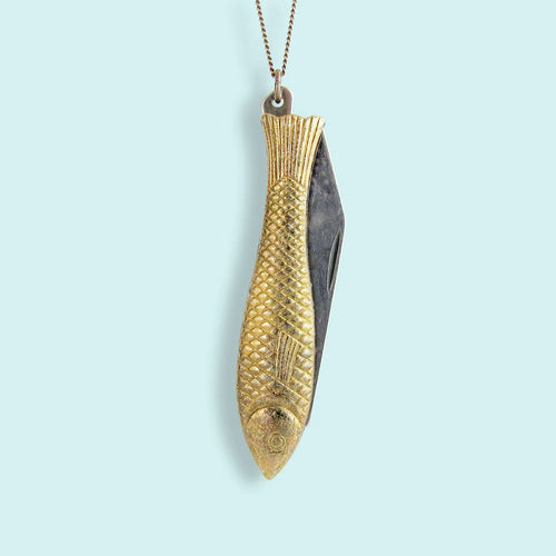 Pocket knife shaped as a gold fish on a chain necklace. light blue background. 