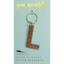 Load image into Gallery viewer, Gold glittery letter &quot;L&quot; keychain on a light blue card with &quot;you sparkle&quot; in gold text, displayed against a white background.