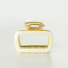 Load image into Gallery viewer, White rectangular metal claw clip with gold hardware displayed on a white background. 