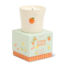 Load image into Gallery viewer, Soy wax candle in a white ceramic cup container with small orange motif, displayed on the Citrus Spritz product box with illustrated citrus graphics, against a white background. 