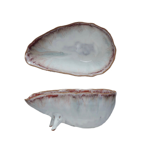 Two ceramic glazed bowls with feet on a white background.