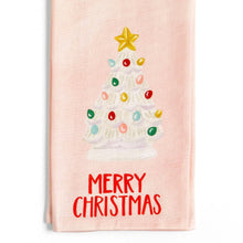 Load image into Gallery viewer, Light Pink cotton kitchen towel featuring a vintage-style white Christmas tree with colorful bulb ornaments and a gold star topper above a red &quot;Merry Christmas&quot; text, displayed against a white background. 