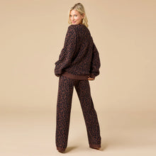 Load image into Gallery viewer, Back view of a person wearing an espresso-colored lounge set with a black leopard print pattern, shown against a soft beige background. 
