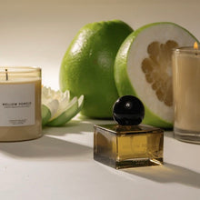 Load image into Gallery viewer, Pour NY Mellow Pomelo candle and parfum bottle with green pomelo fruit and white flower on a light surface. 